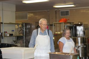 Church volunteers in aprons at Meals on Wheels.