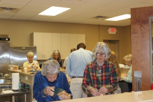 Saturday Servants making sandwiches in the Church kitchen.